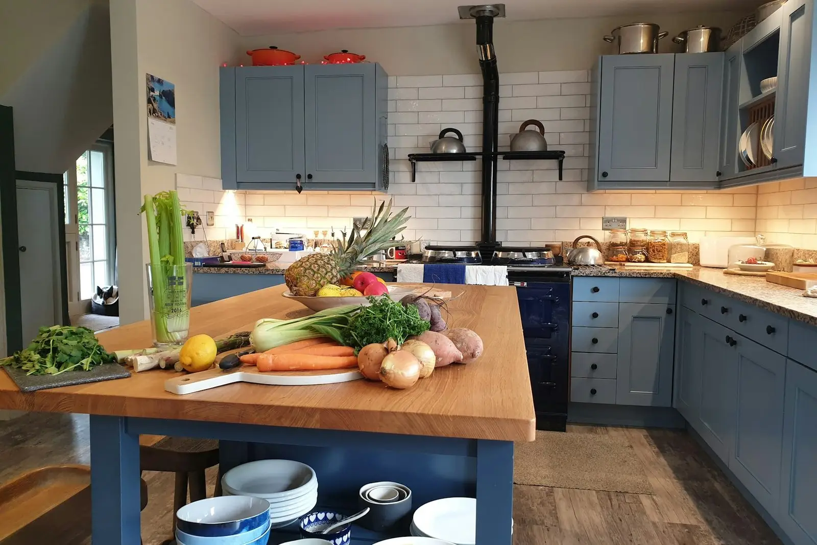 Kitchen with a wooden island, painted units and a range cooker